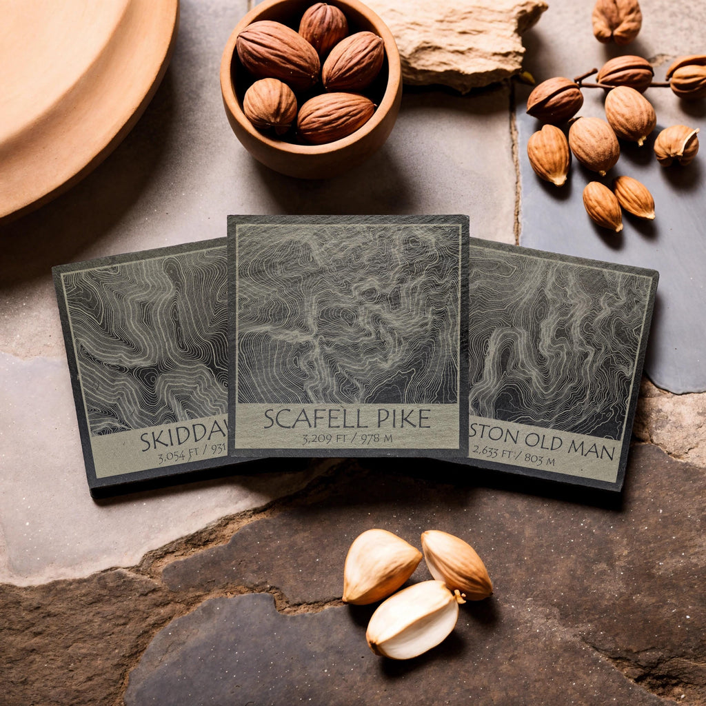 Skiddaw, Scafell Pike and Coniston Old Man slate coasters arranged on a stone tabletop